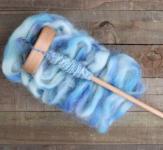 Drop spindle with blue yarn.
