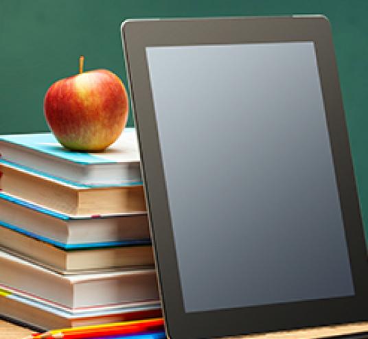 Tablet leaning on stack of books